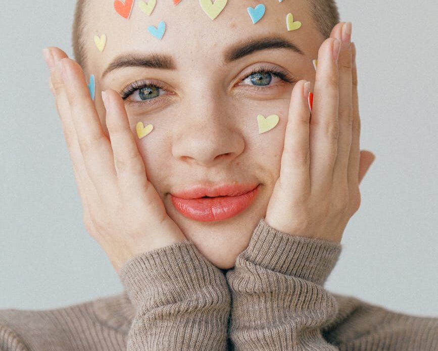 young positive woman with many stickers on face