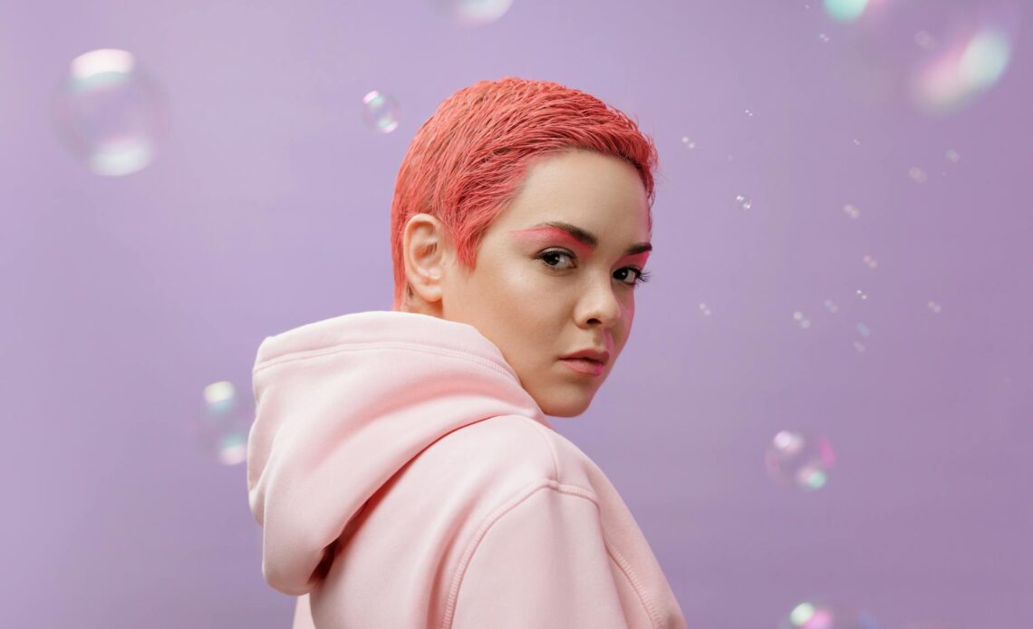 a portrait of a woman in a pink hoodie