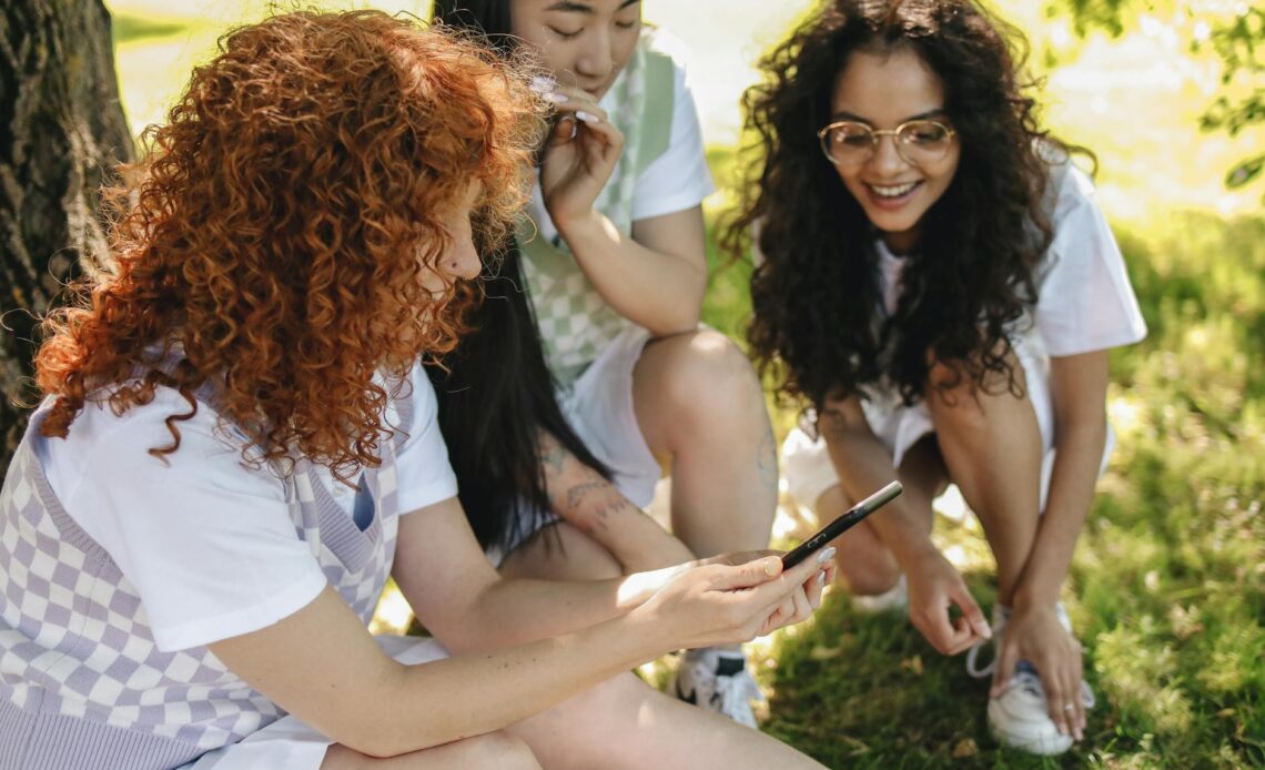 group of students looking at a smartphone together