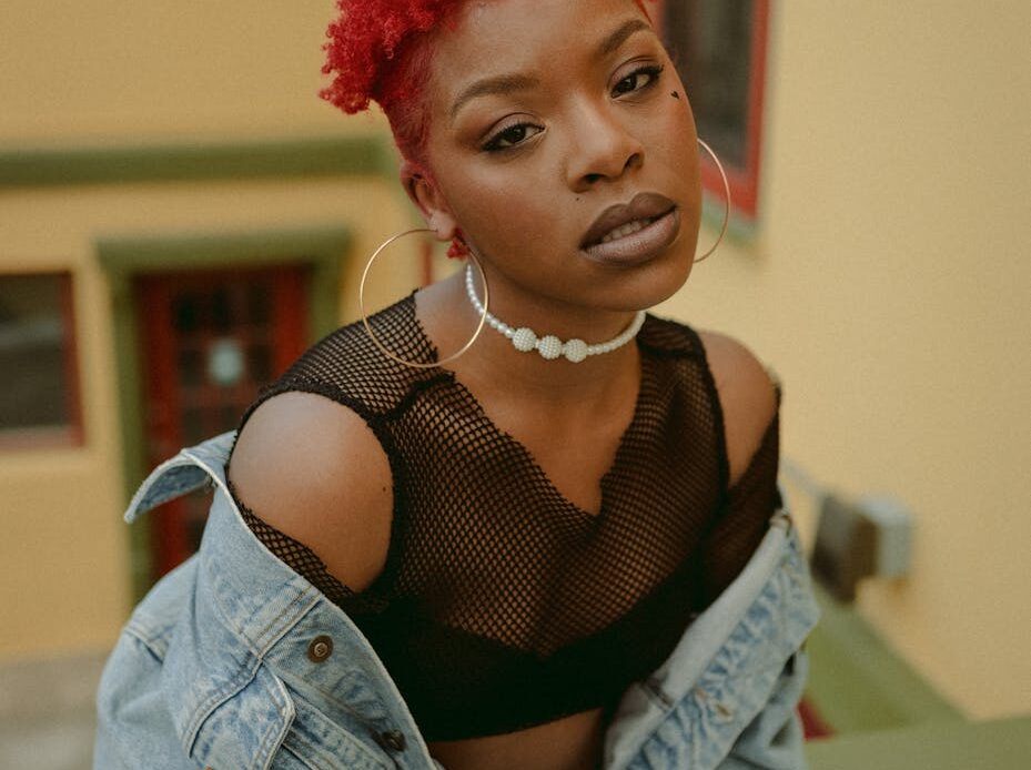 redhead woman with african hairstyle in denim jacket