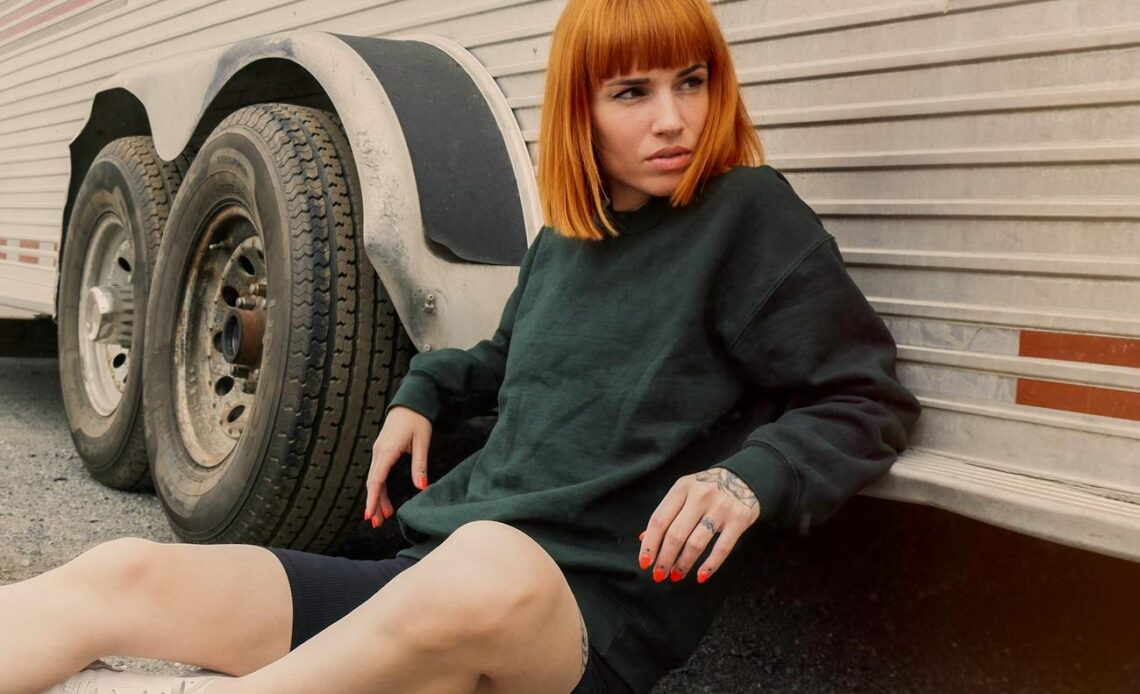 tourist sitting on the ground leaning against a caravan