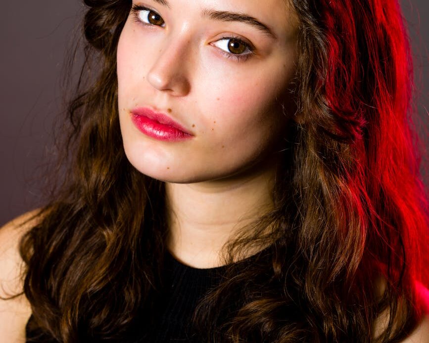 teenage female closeup seated headshot red gel hair light serious