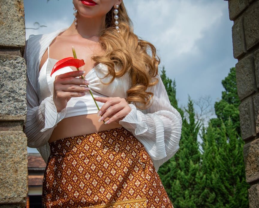 a woman in a skirt and top holding a drink