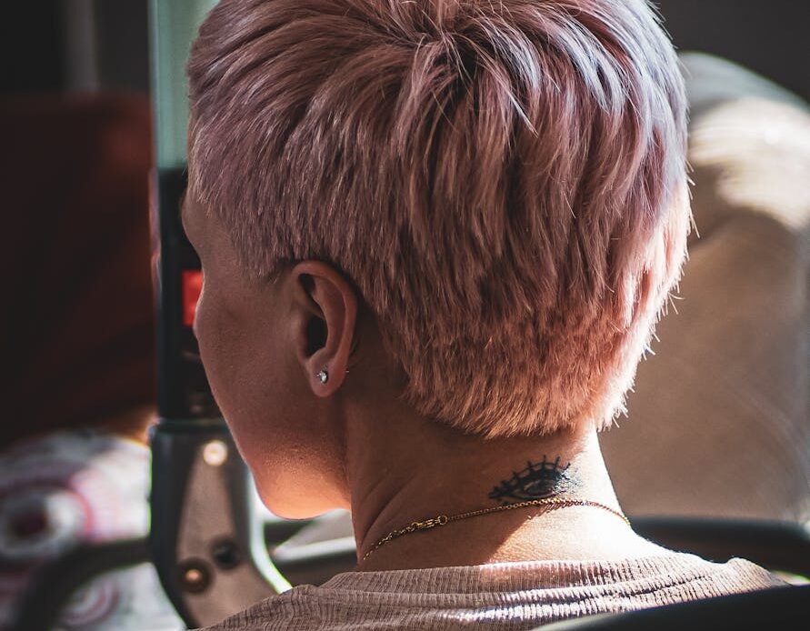 a woman with pink hair sitting in a bus