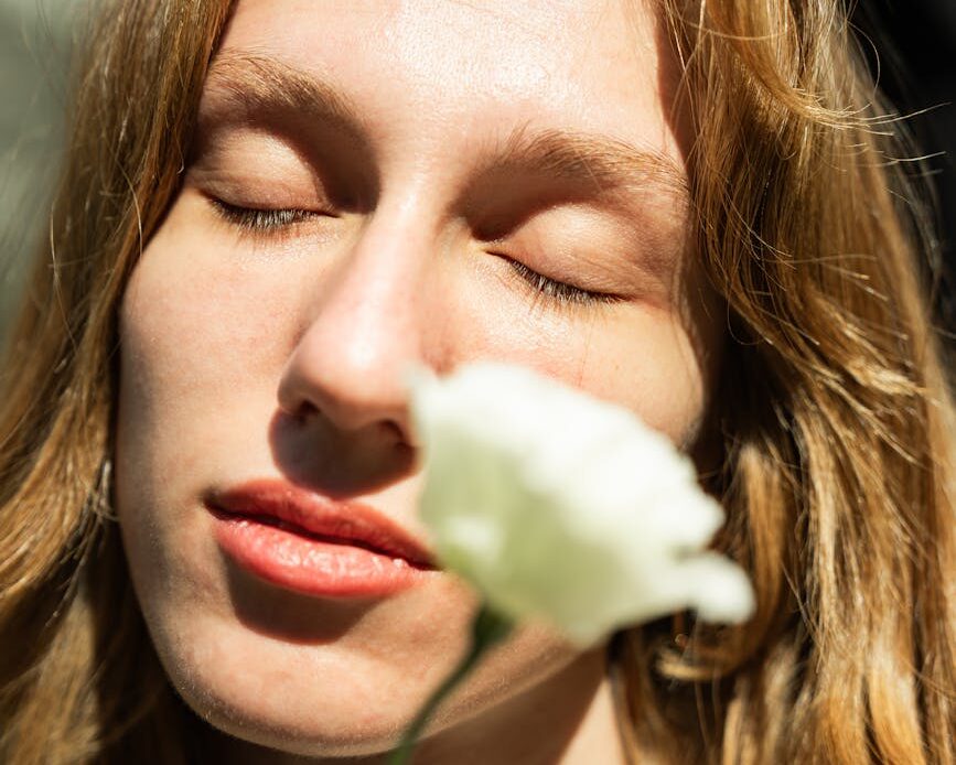 a woman with long hair is holding a flower