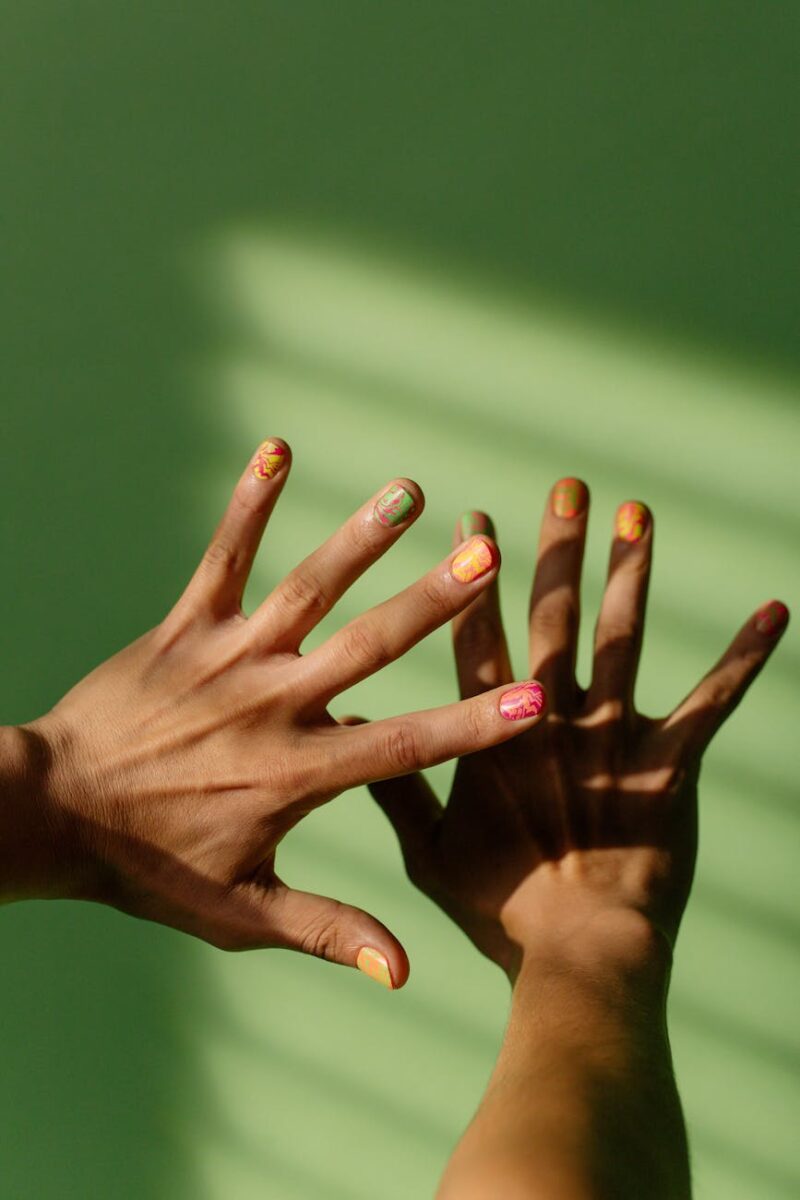 close up shot of hands with colorful nail polish