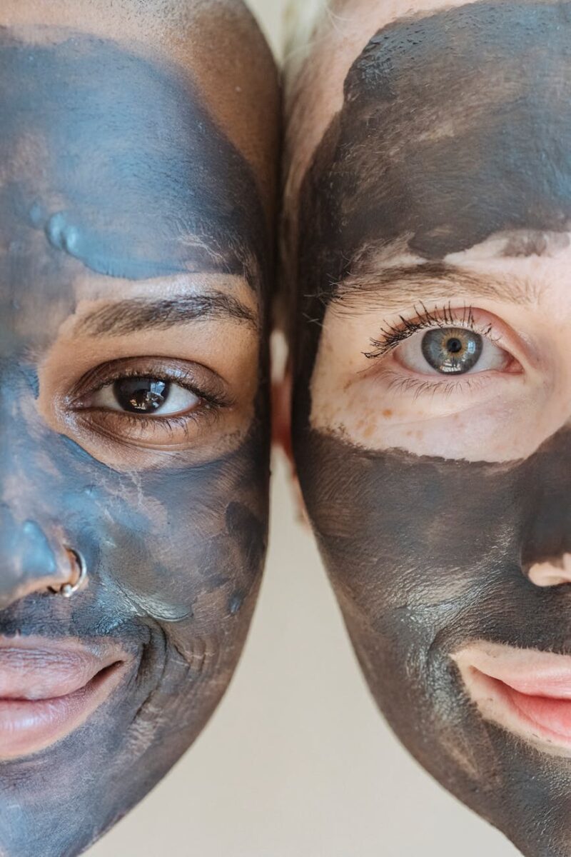 diverse crop females smiling with clay mask