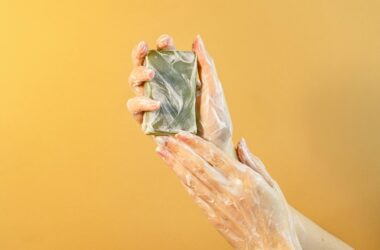 hands with soap bubbles holding a bar of soap