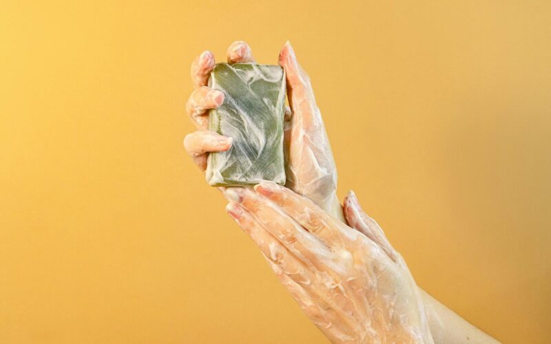 hands with soap bubbles holding a bar of soap