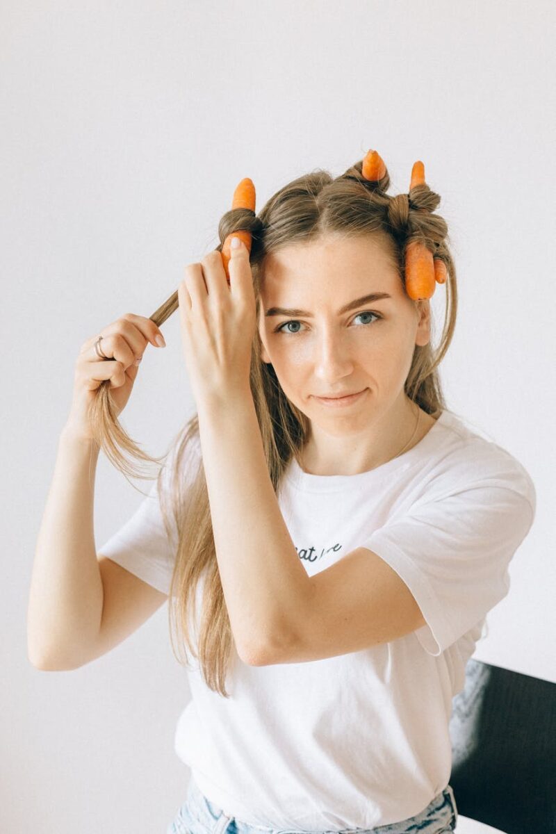 woman in white crew neck t shirt holding her hair