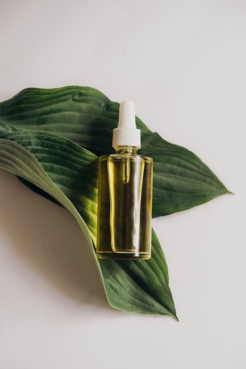 a bottle of serum on green leaves