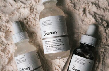 dropper bottles of skincare products from the ordinary lying on talcum powder