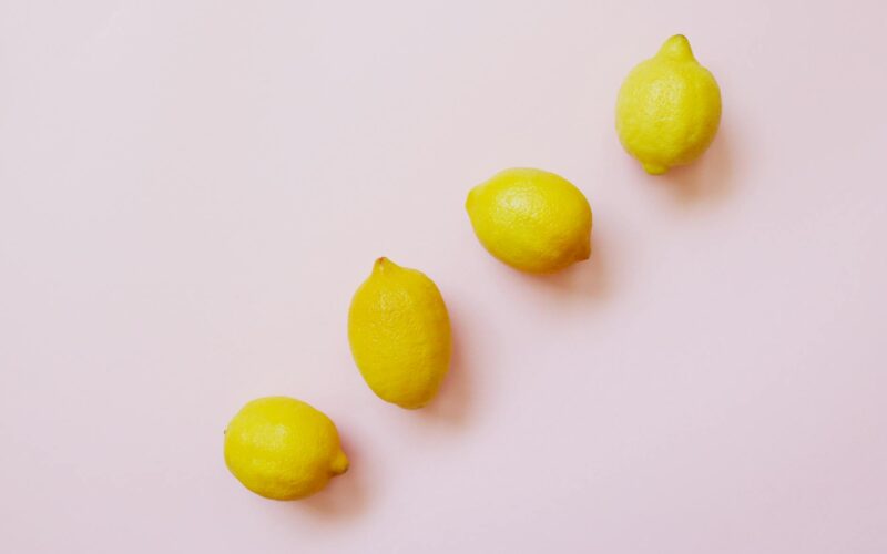 four lemon fruits forming straight line on a white background