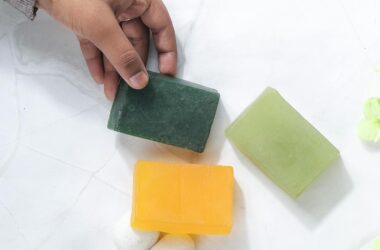 hand picking natural soap bars on marble surface