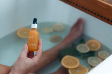 person holding orange and black plastic bottle