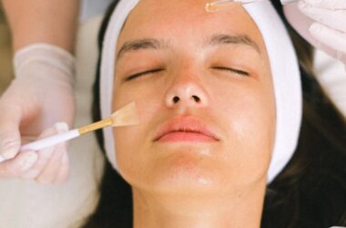 beautician putting cosmetic product on female client face