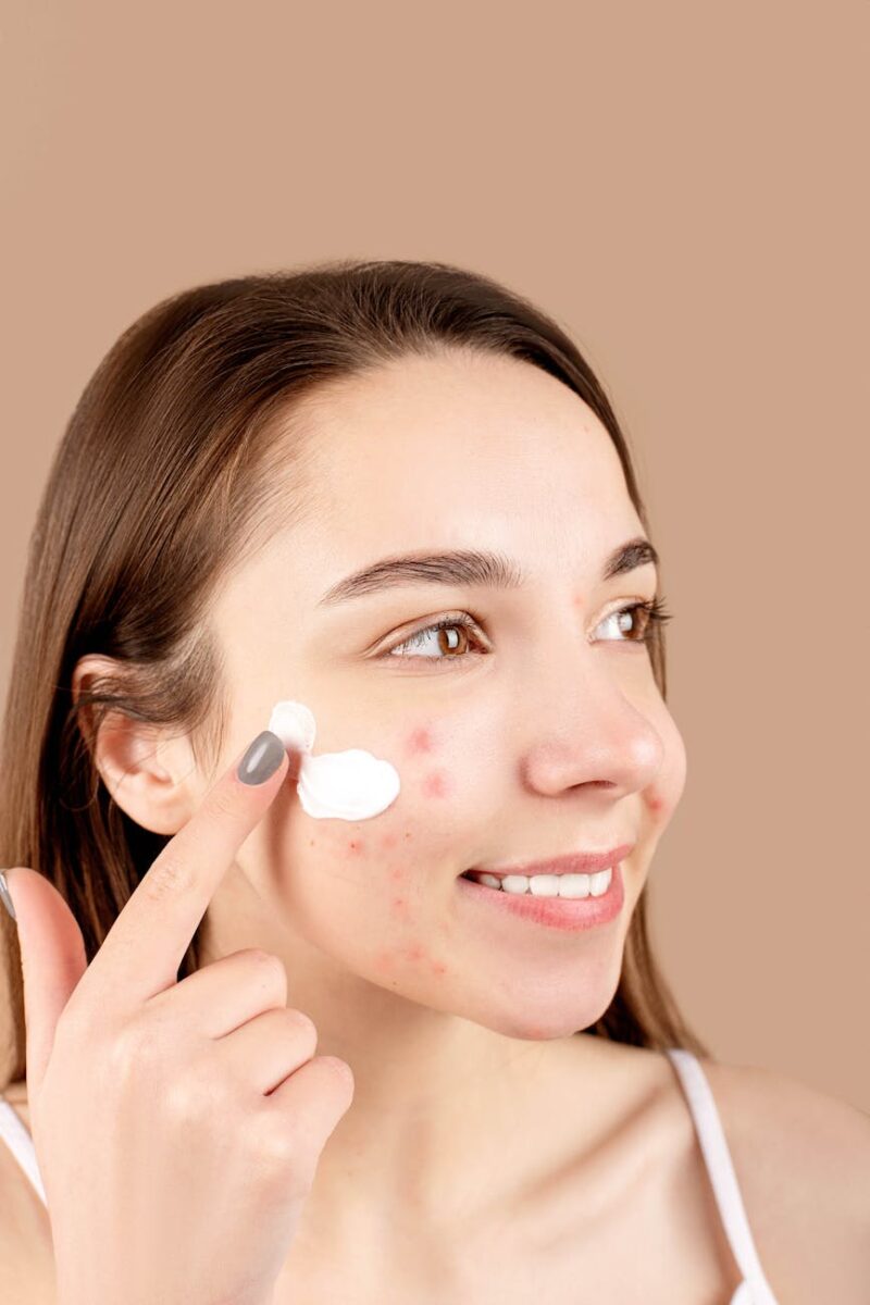 a woman putting cream on her face