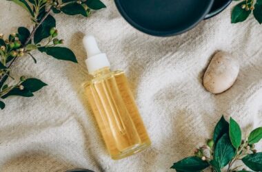 green leaves on branches near the glass serum bottle