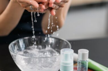 woman in black shirt washing her face with water