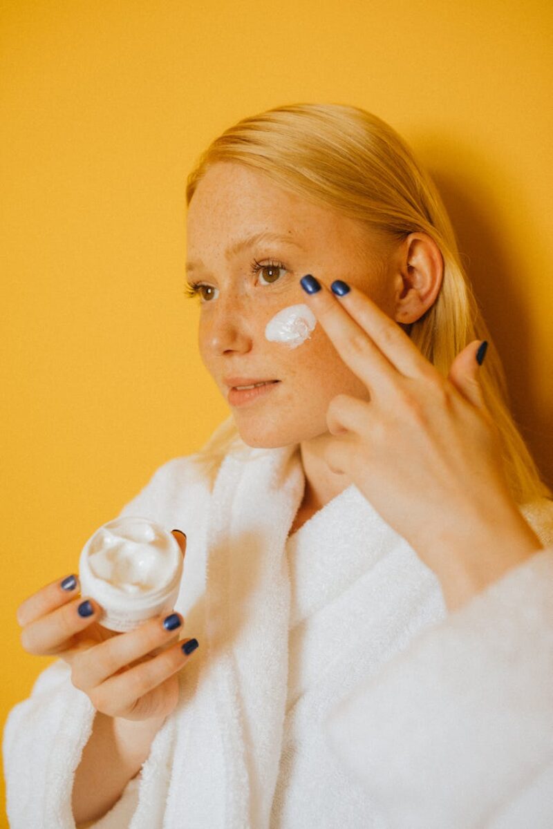 woman putting cream on her face