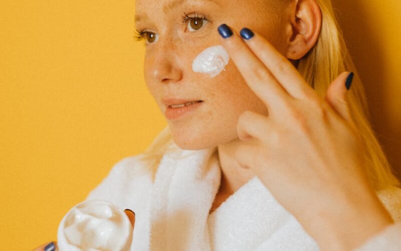 woman putting cream on her face